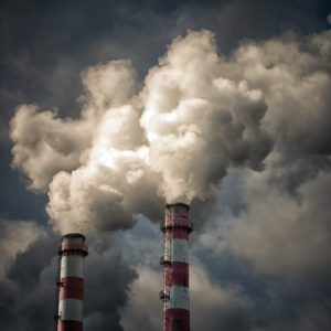 Two pipes smoke againts the cloudy sky