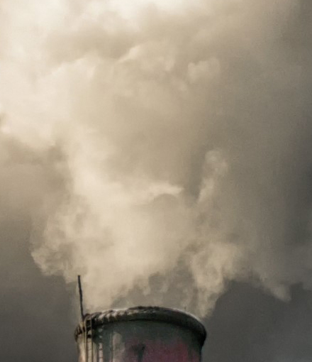 Two pipes smoke againts the cloudy sky